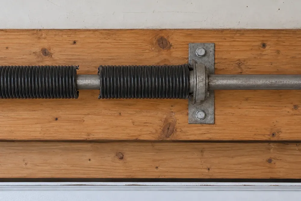 Snapped torsion spring with a clear gap in the coil beside the center bearing plate
