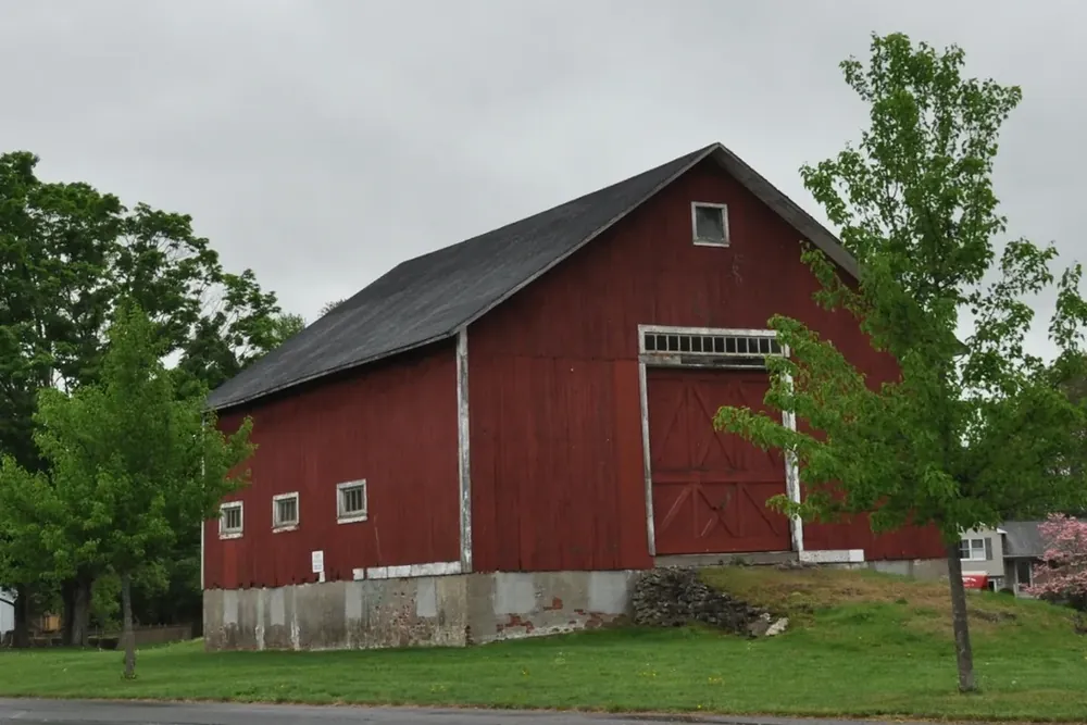 Red School Street Barn among trees at School Street Park in Agawam, Massachusetts