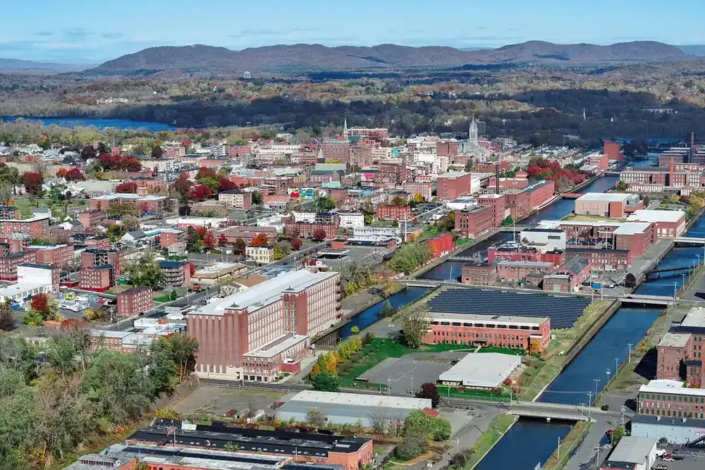 Aerial view of Holyoke's mill canals and brick neighborhoods with hills beyond, Massachusetts