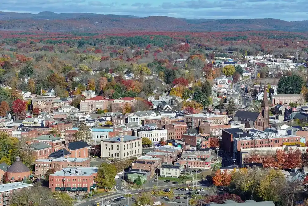 Aerial view of downtown Northampton, Massachusetts, among autumn trees with hills on the horizon