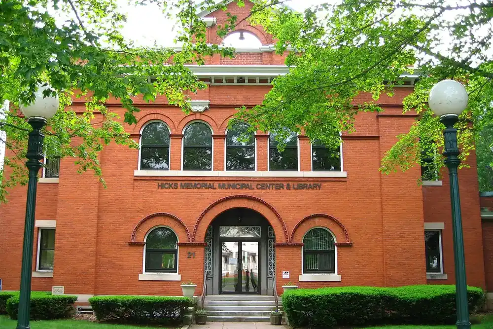 Brick Hicks Memorial Municipal Center and Library framed by trees in Tolland, Connecticut